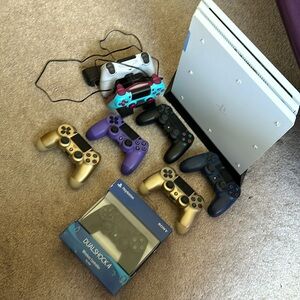 PlayStation 4 pro 1TB; 7 used controllers, 1 unused; 2 controller charging dock.